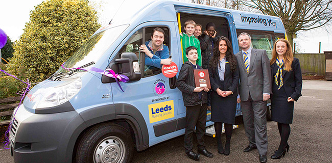 Jason Manford and members of Leeds Building Society presenting pupils with a bespoke bus
