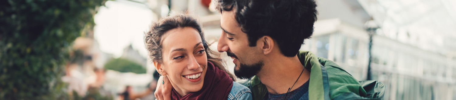 Two people with their arms around each other smiling