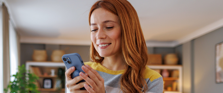 A person smiling at their phone