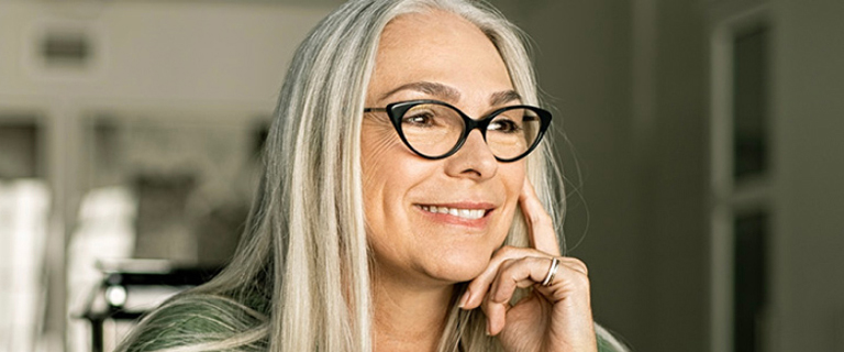 A person smiling with their hand to their face