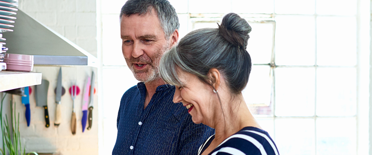 Two people smiling in a kitchen