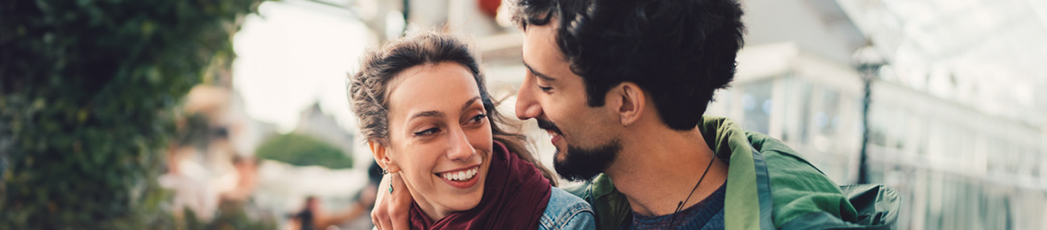Two people with their arms around each other smiling