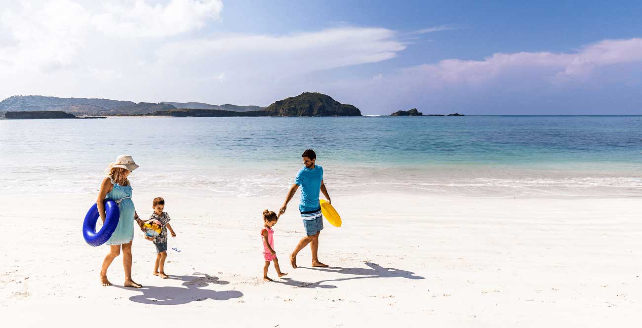 family taking a stroll on a sunny beach