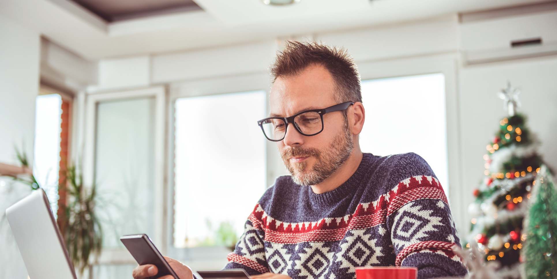 man in christmas jumper on his phone