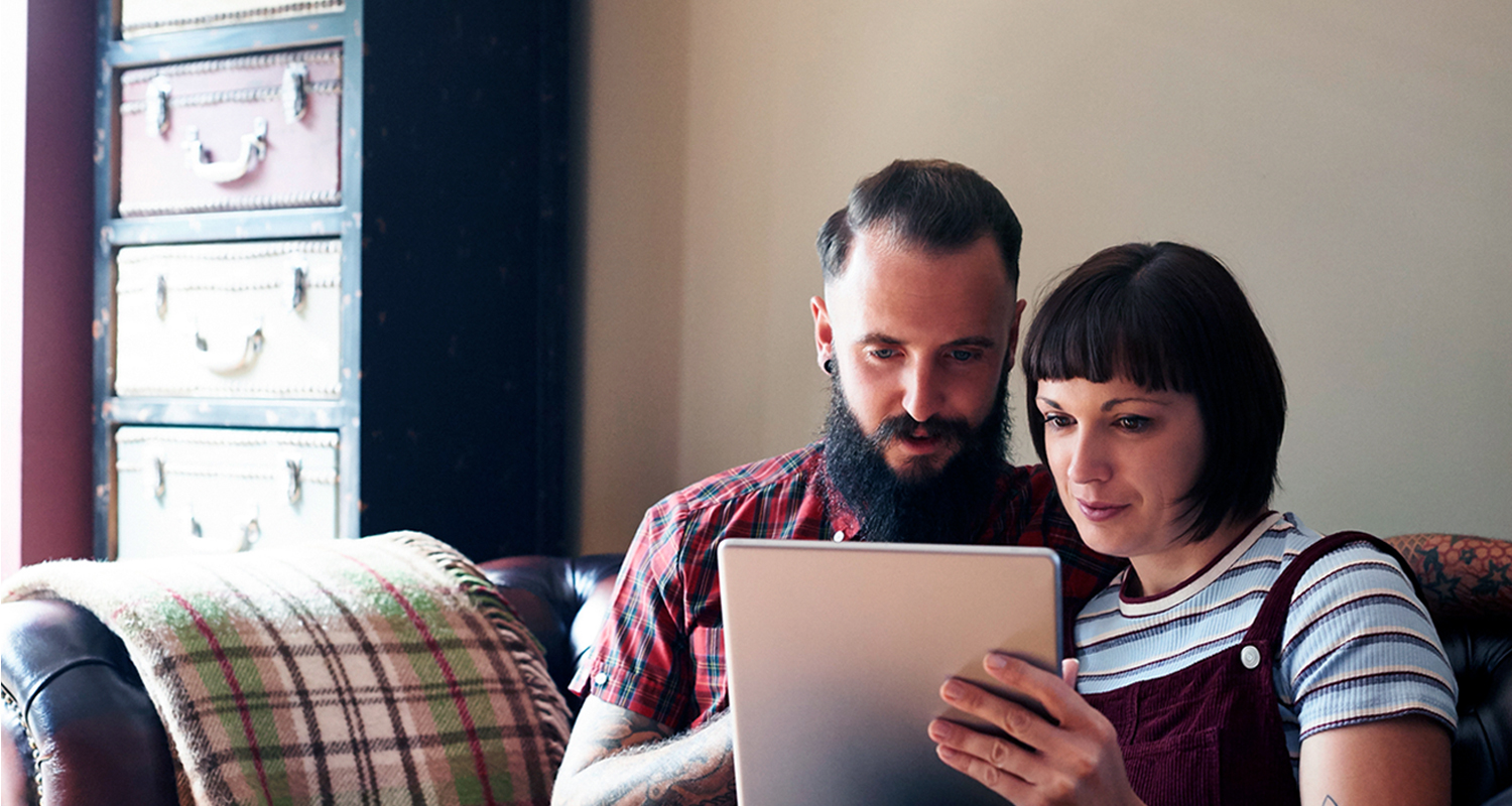 two people look at device together