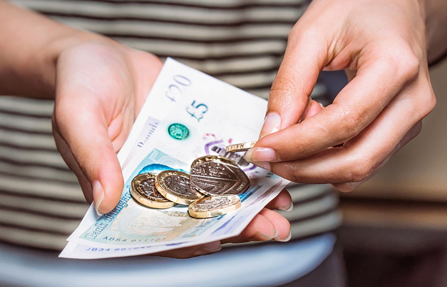 person counting through a pile of money