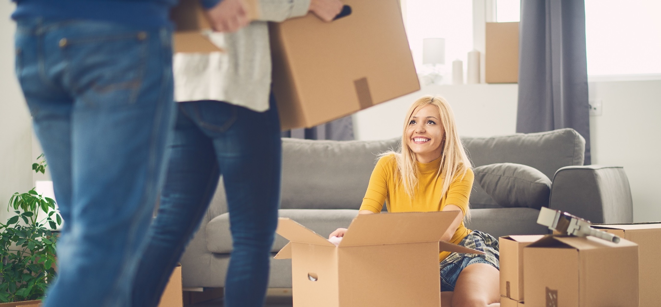 woman sat down looking up at a someone carrying a box