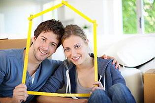 man and woman looking through yellow house stencil