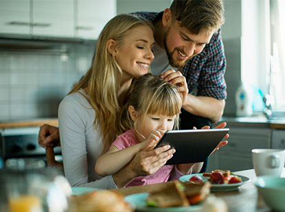 family looking at tablet in kitchen