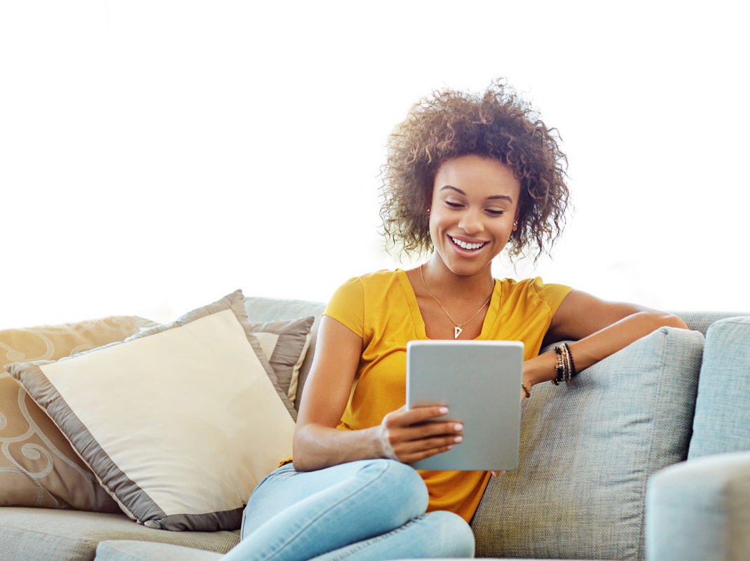 A person sat on a sofa looking at a piece of paper