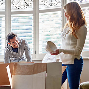 Man and woman unpacking moving boxes