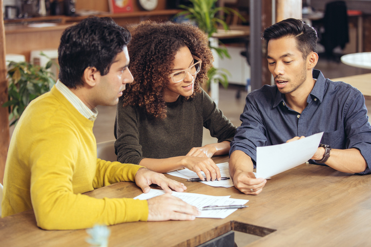 3 people talking about paperwork