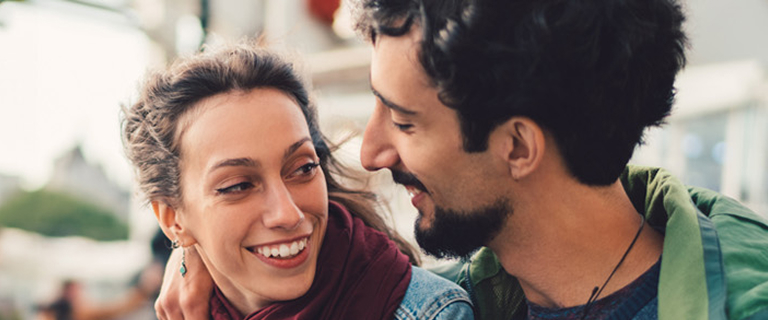 Two people with their arms around each other smiling