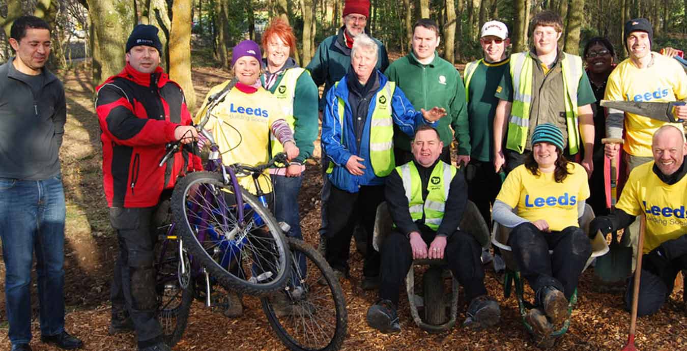 Members of Leeds Building Society in the woods with tools and bicycles