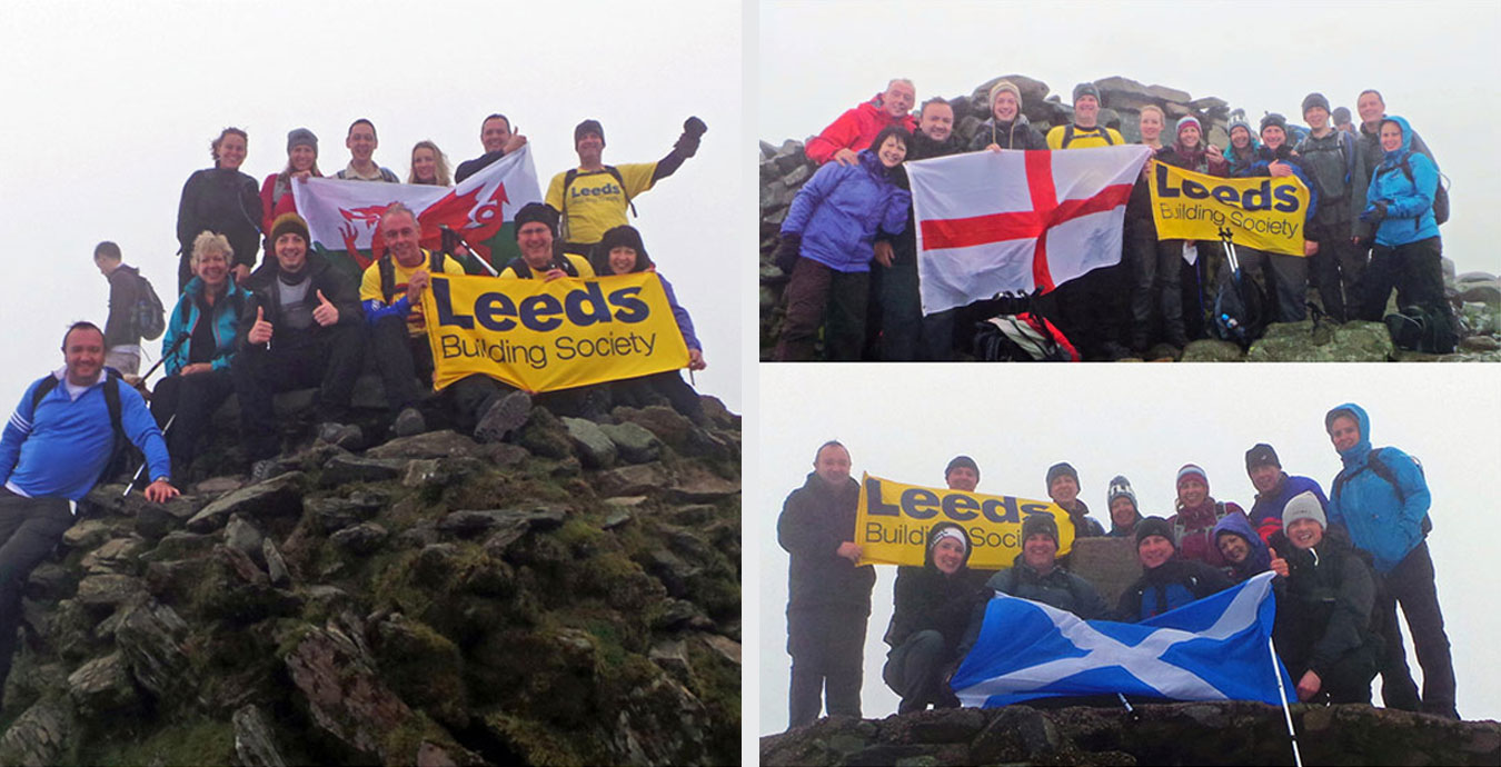 A group of people at the top of a mountain with a Leeds Building Society banner