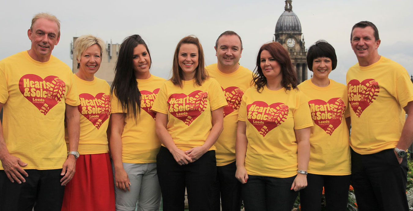 A group of people wearing matching 'Heart & Sole' t-shirts