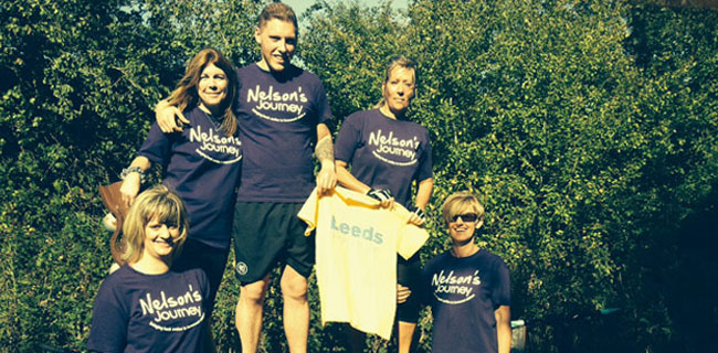 A group of people wearing matching 'Nelson's Journey' t-shirts