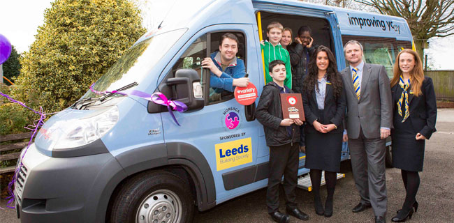 Jason Manford and members of Leeds Building Society presenting a bespoke bus to pupils from Sutherland House School