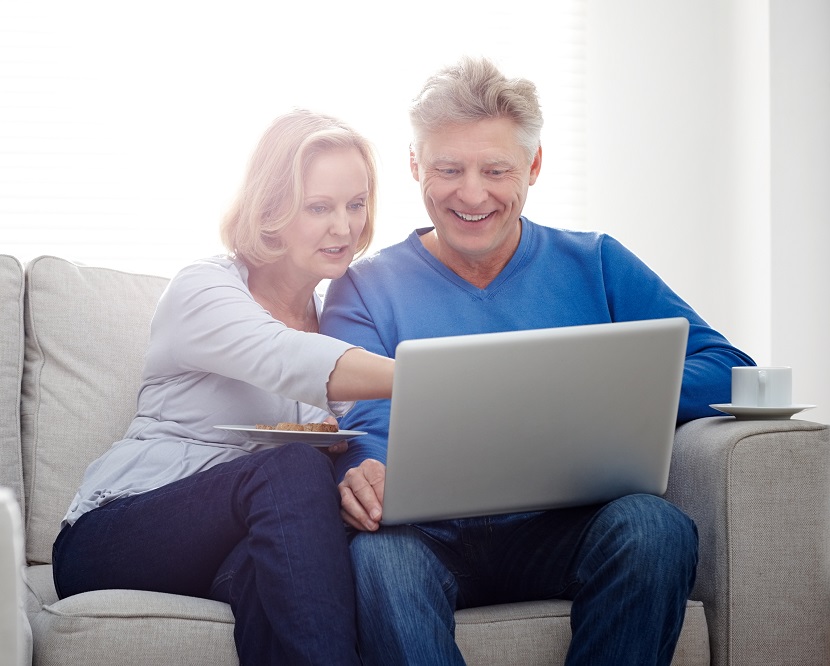 Two people sat down looking at a laptop